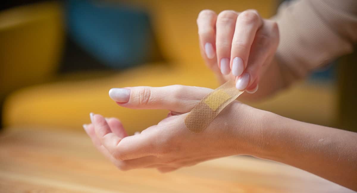 An image of someone putting on a plaster