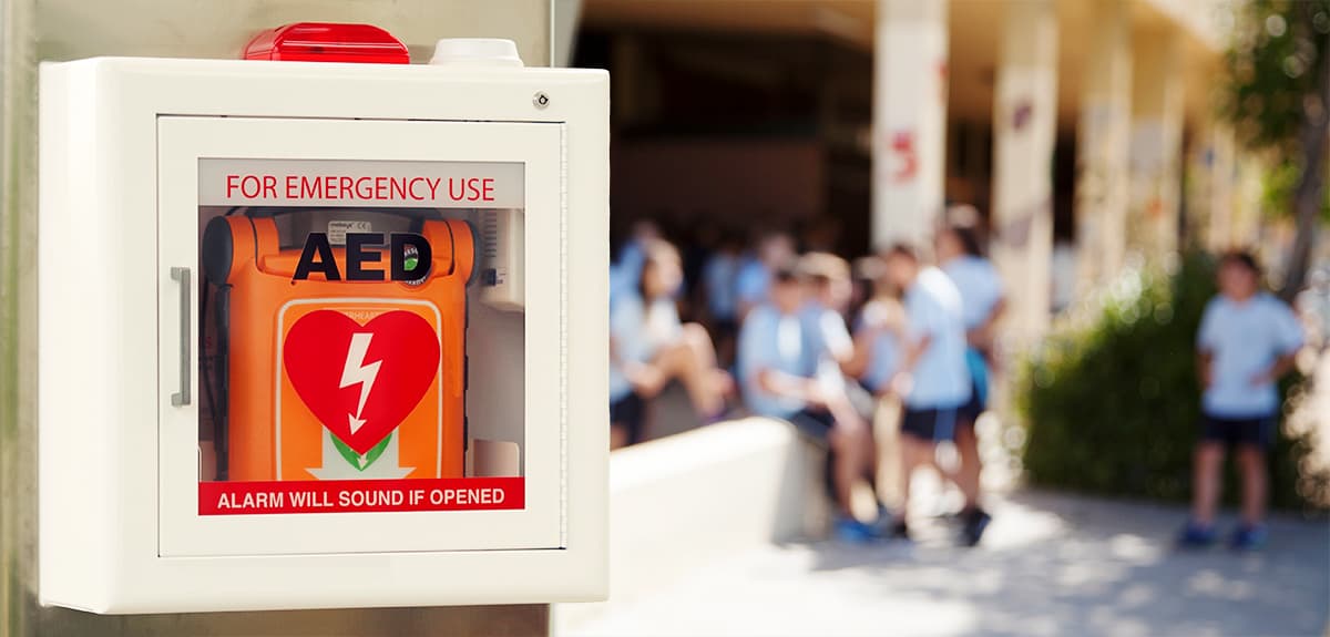 A defibrillator or AED on the wall in a school ready to be used