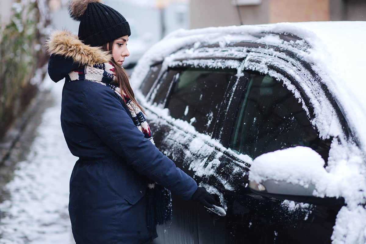 A woman getting into her car during winter