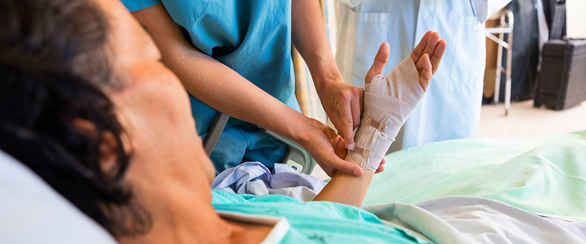 Nurse applies a crepe bandage to the arm of a patient