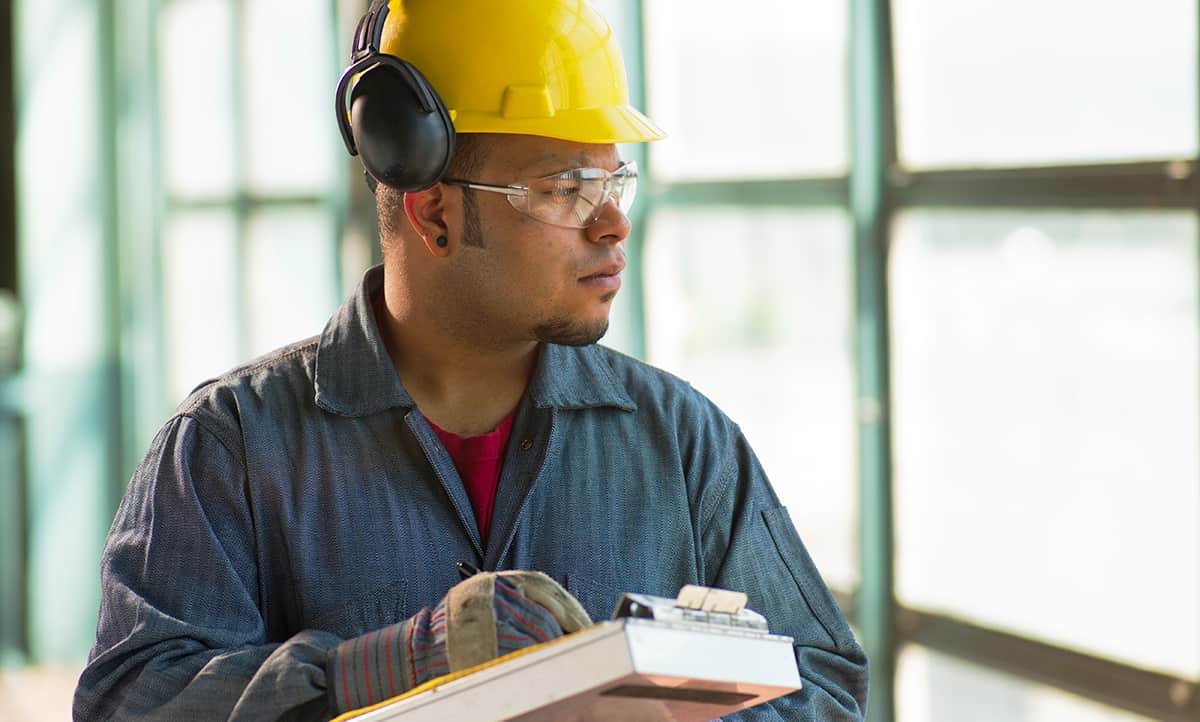 Construction worker conducts a risk assessment to inform health and safety