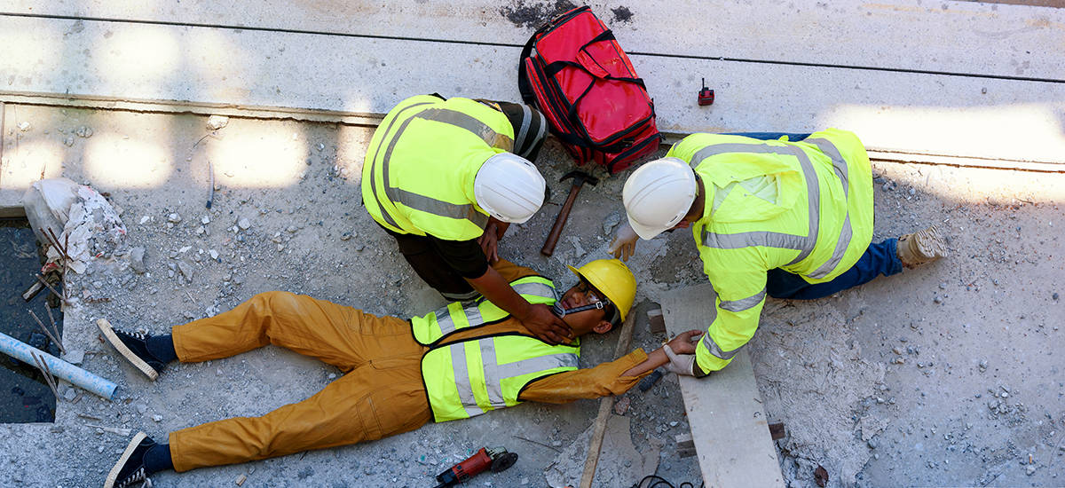 Construction workers attend to an injured co-worker