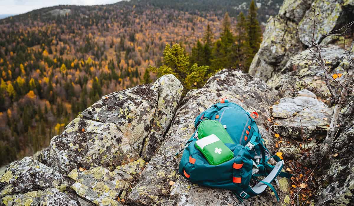 An image of a first aid kit on a rucksack looking over a forest