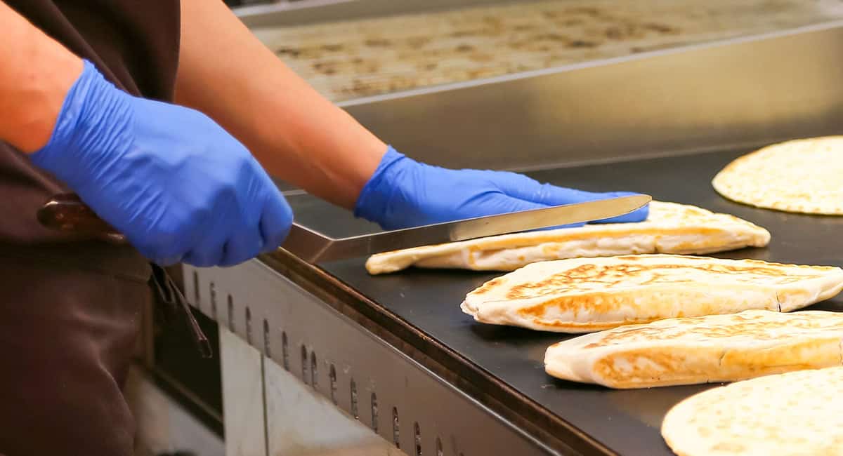 An image of latex gloves being used in a cooking environment
