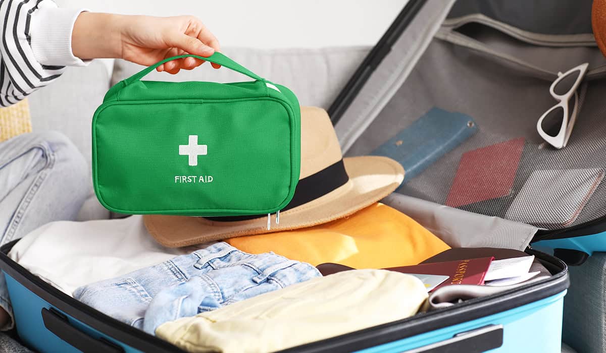 First aid kit being placed in a suitcase